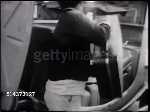 1966: UNITED AIRLINES FLIGHT CREW: Pilot, Co-pilot & engineer checking checklist. GROUND CREW: Baggage moving on conveyor belt, handlers placing suitcases into cart. Two flight attendants (stewardesses) walking up aisle, VS Handlers driving carts.